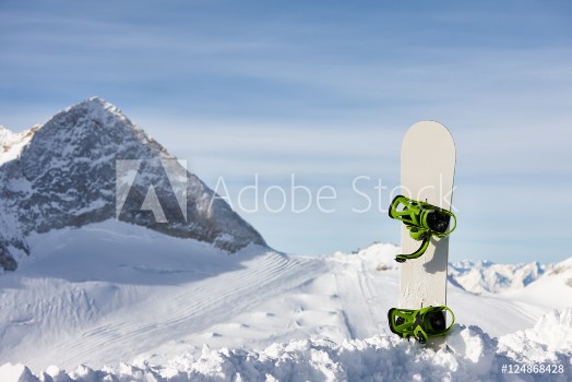 Picture of Snowboard in snow slope on a beautiful mountain background